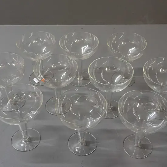 10 hollow-stemmed champagne glasses with matching etched foliate motifs - one has some fretting around rim H-115 D-90