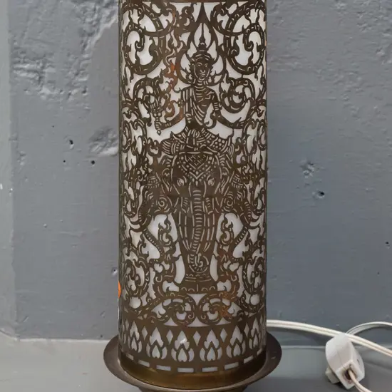 cylindrical pierced brass table lamp with frosted glass shade, on spun brass base - Thai or Indian motifs - some dents