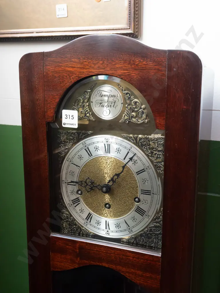 reproduction mahogany free-standing clock w/ glazed bevel-edged arched-top door brass arch-top face silver band Image 1++