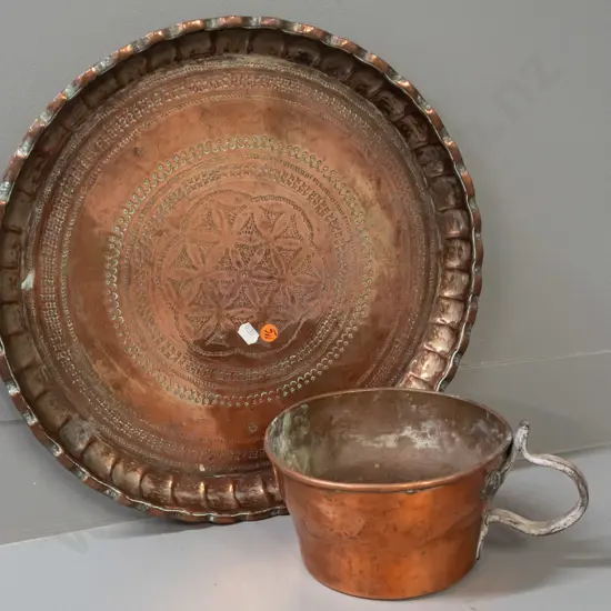 vintage copper vessel with cast metal handle and a coppered metal tray with incised decoration, wall hanging loop on