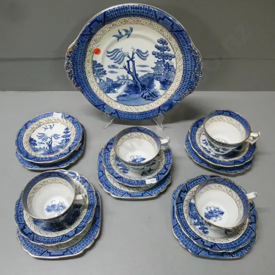 Booths 'Real Old Willow' gilt-finished blue-and-white teaware: 4x trios & cake plate, extra plate & saucer (w/ chip).