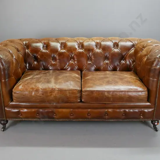 brown leather deep button and pleated rolled-arm chesterfield 2-seater settee with brass studded front and sides, on