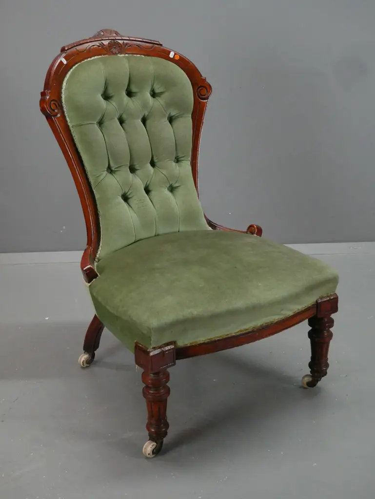 Victorian walnut lady's chair with carved shaped back, turned fluted legs, deep button back, porcelain & brass casters. Image 1++