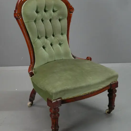 Victorian walnut lady's chair with carved shaped back, turned fluted legs, deep button back, porcelain & brass casters.