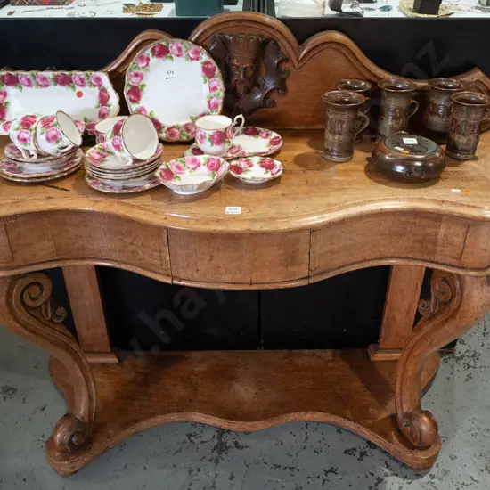 Victorian oak console table with shaped upstand, figural carving in shaped roundel, scrolling carved front legs on