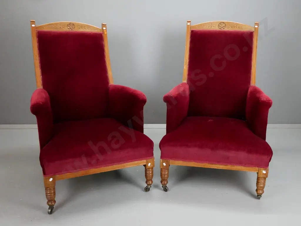 pair of late Victorian walnut armchairs w/ carved crest top rail, turned legs on metal casters, upholstered arms - arms Image 1++