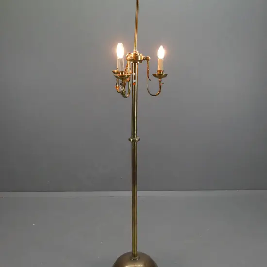 brass standard lamp with 3 curved arms holding upturned light fittings, circular base with 3 lion's paw feet - stem is