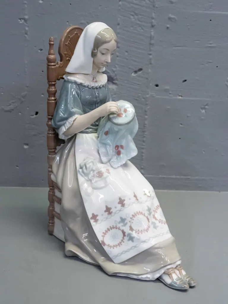 Lladro figure - woman with needlework seated in chair H-280 L-210 front to back Image 1++