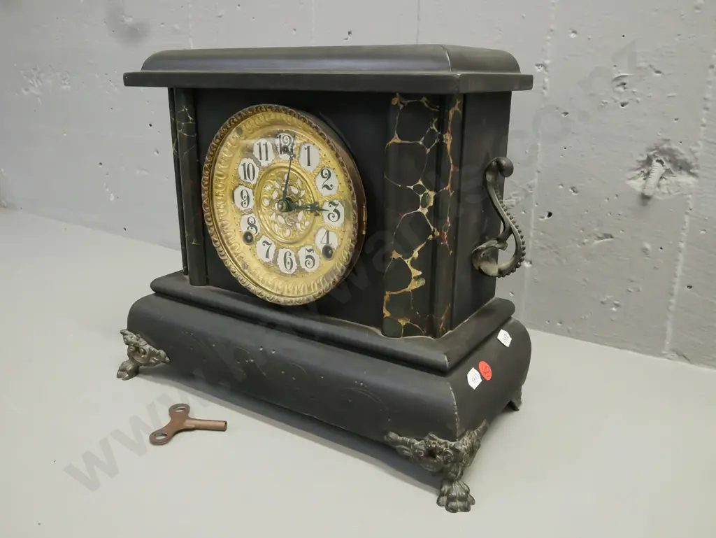 ebonised wooden mantel clock w/ marbled corners, applied scrolling cast handles, paw feet, gilded face. Gilbert Clock Co Image 1++