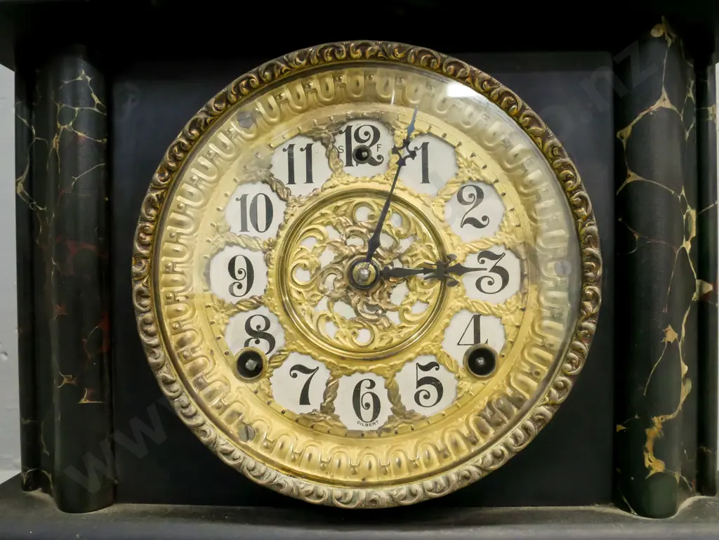 ebonised wooden mantel clock w/ marbled corners, applied scrolling cast handles, paw feet, gilded face. Gilbert Clock Co Image 1++
