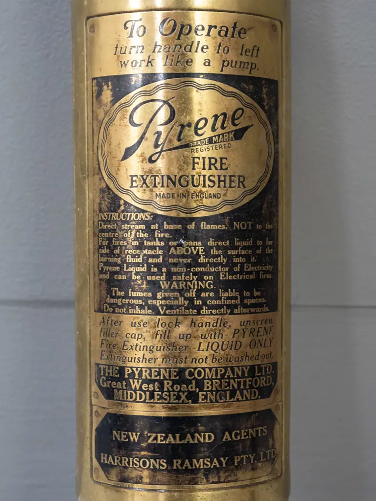 small brass hand-pump fire extinguisher - Pyrene Made in England, w/ Harrison's Ramsay NZ markings - minor denting L370 Image 1++