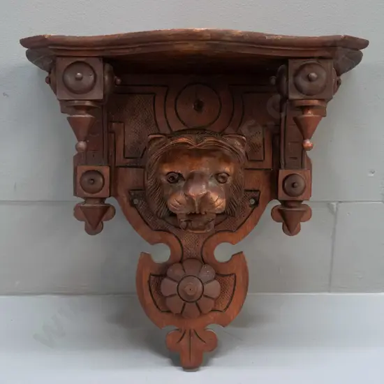 Victorian carved walnut and oak wall bracket with lion's head and flower, shaped top and brackets, drop finials - has