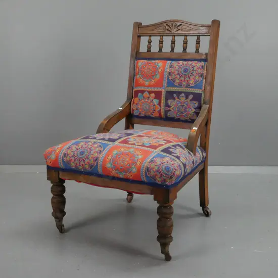 Edwardian beech bedroom chair with carved back rail, turned gallery supports, turned front legs on brass bucket casters