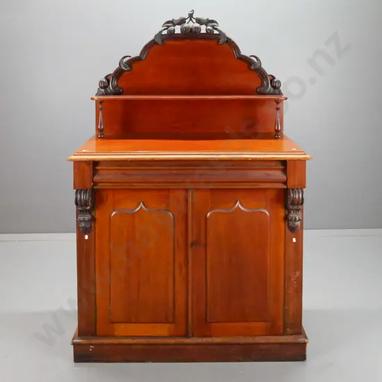 NZ colonial cedar carved-back chiffonier with shaped top shelve, drawer over 2 shield-panelled doors, kauri interior.