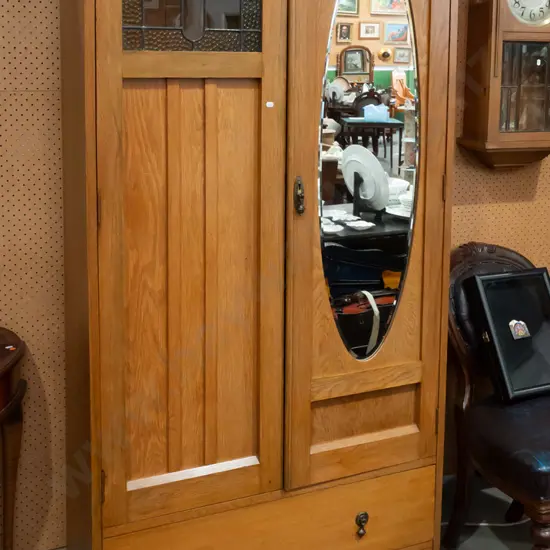 vintage oak 2-door wardrobe with oval bevelled edge mirror in one, small leadlight panel in other above slatted panel,