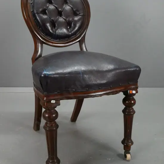 Victorian mahogany medallion-back side chair with carved back, turned fluted legs on porcelain casters, deep-button