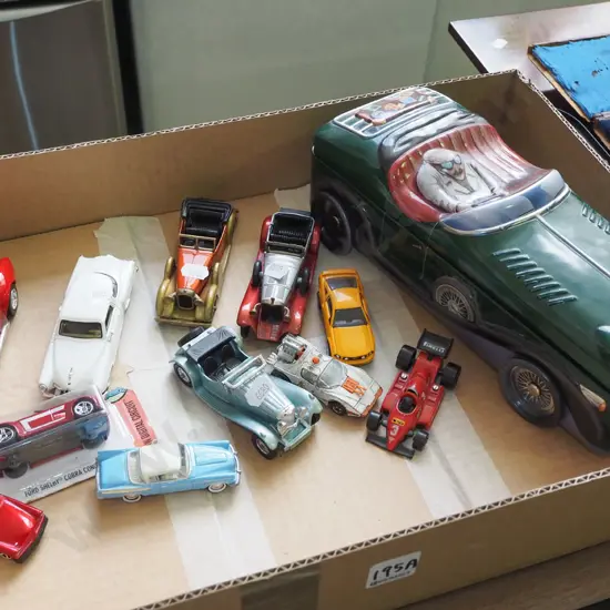 box of die-cast vehicles and a roadster shaped tin