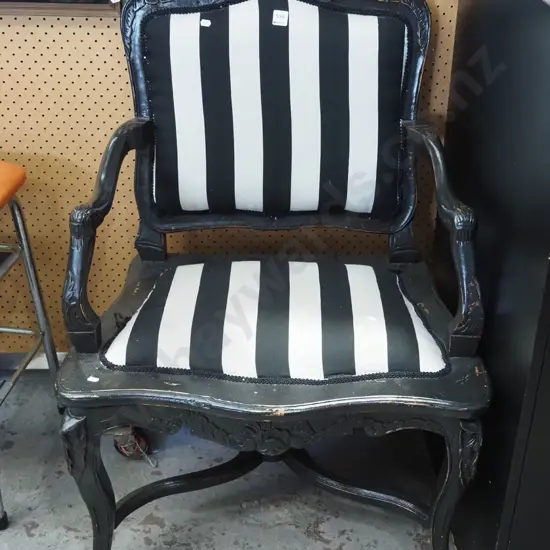 carved black painted wooden armchar with black and white upholstery