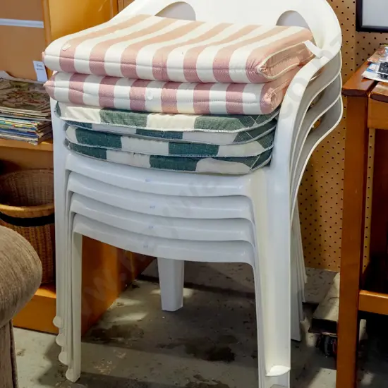 4x white plastic stacker chairs and 4x striped cushions