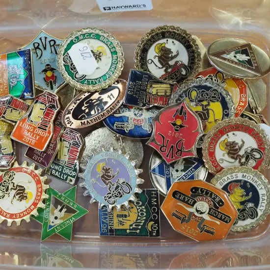 container of brass monkey and other rally badges