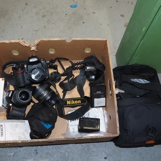 box; 2x Nikon digital SLR cameras, 3 lenses, flash, tripod etc.