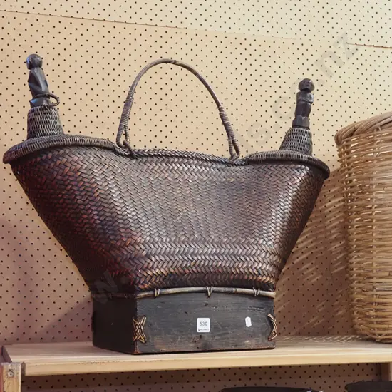 dark brown wicker basket with 2 tapered handles and carved wooden figural stoppers H600