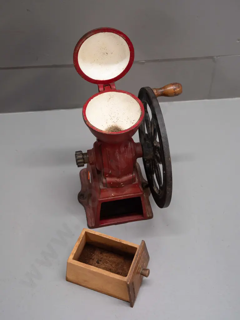 cast iron coffee mill with wooden knob on wheel, wooden wedge shaped drawer. Back of wheel marked Japan. H-245 W-180 Image 1++