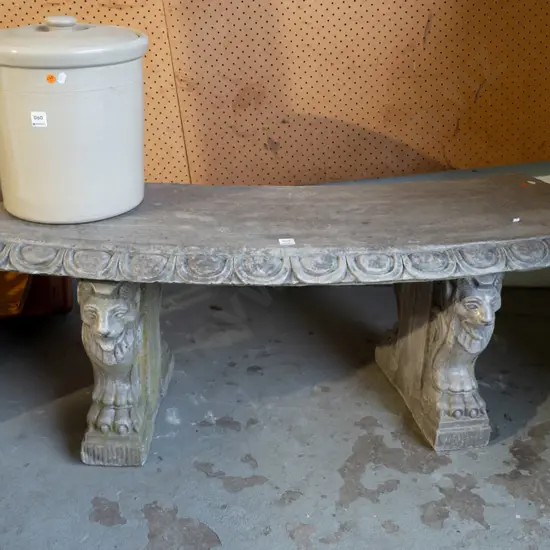 curved cast concrete/composite garden bench sitting on lion's head and paw supports, egg & dart moulding along seat top