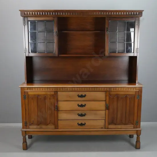 arts and crafts style oak veneer and beech sideboard with shaped moulded cornice above 2 glazed leadlight cupboard