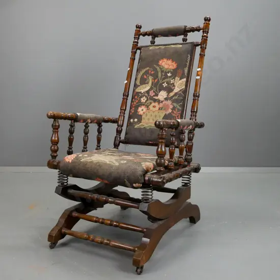 Dexter rocker with turned rails and supports, upholstered seat and back, spring mechanism is working
