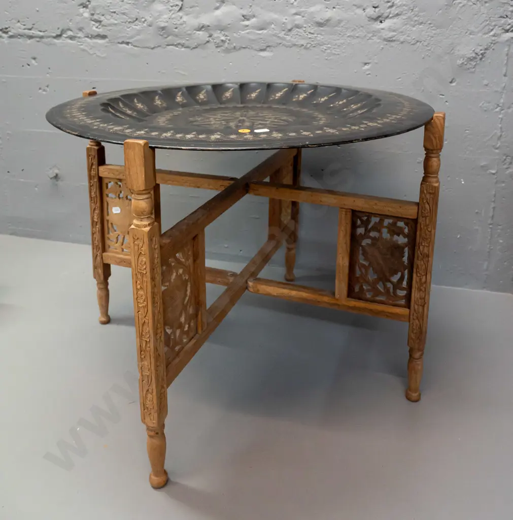 etched metal tole-ware tray on folding pierced and carved timber 4-legged base stamped Made in India. Some wear to black Image 1++