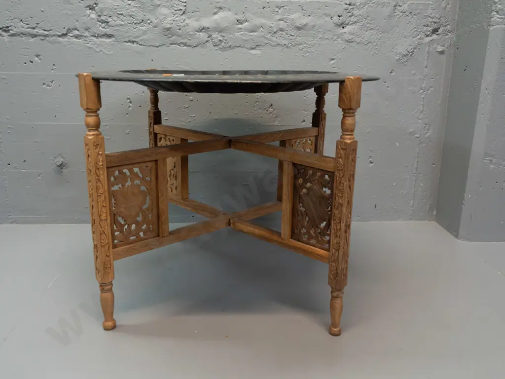 etched metal tole-ware tray on folding pierced and carved timber 4-legged base stamped Made in India. Some wear to black Image 1++