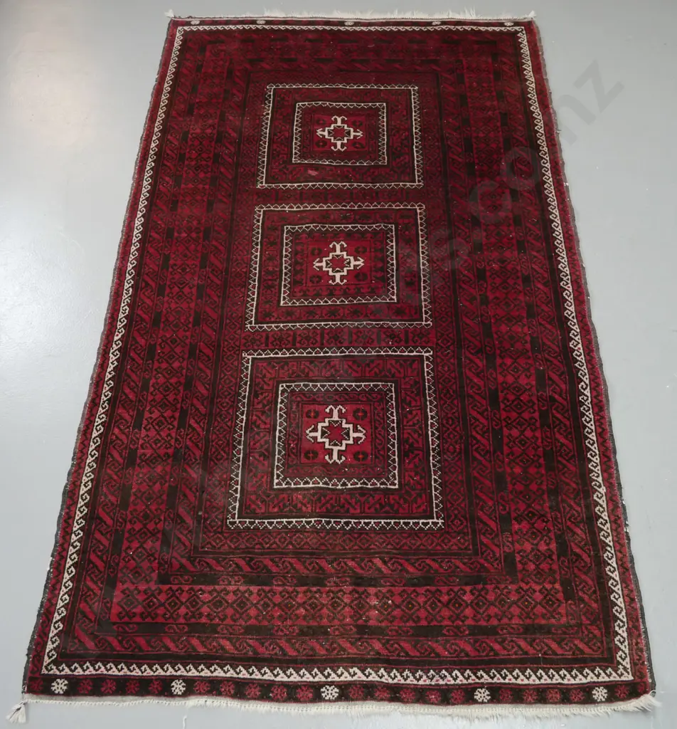 hand knotted woollen Persian style floor mat. Reds, browns, blacks and ivory. Wide borders, 3 geometric central panels. Image 1++