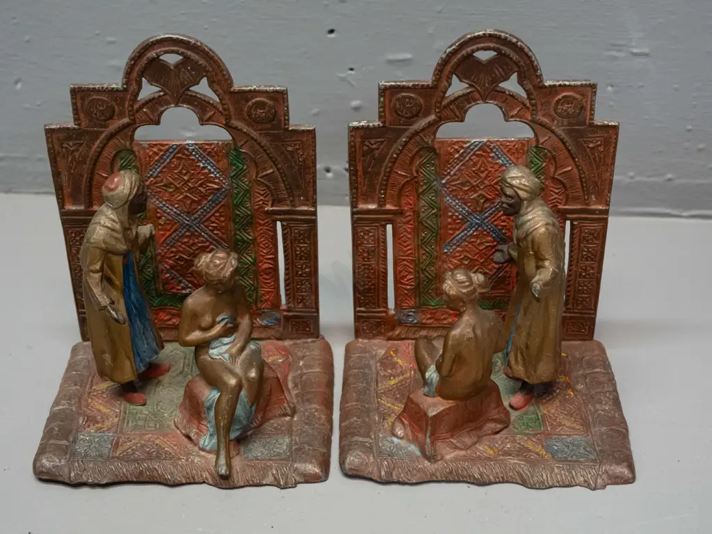 pair of Austrian cast metal book-ends with Arabian scenes and a Thai or Indonesian cast metal seated musician figure - Image 1++