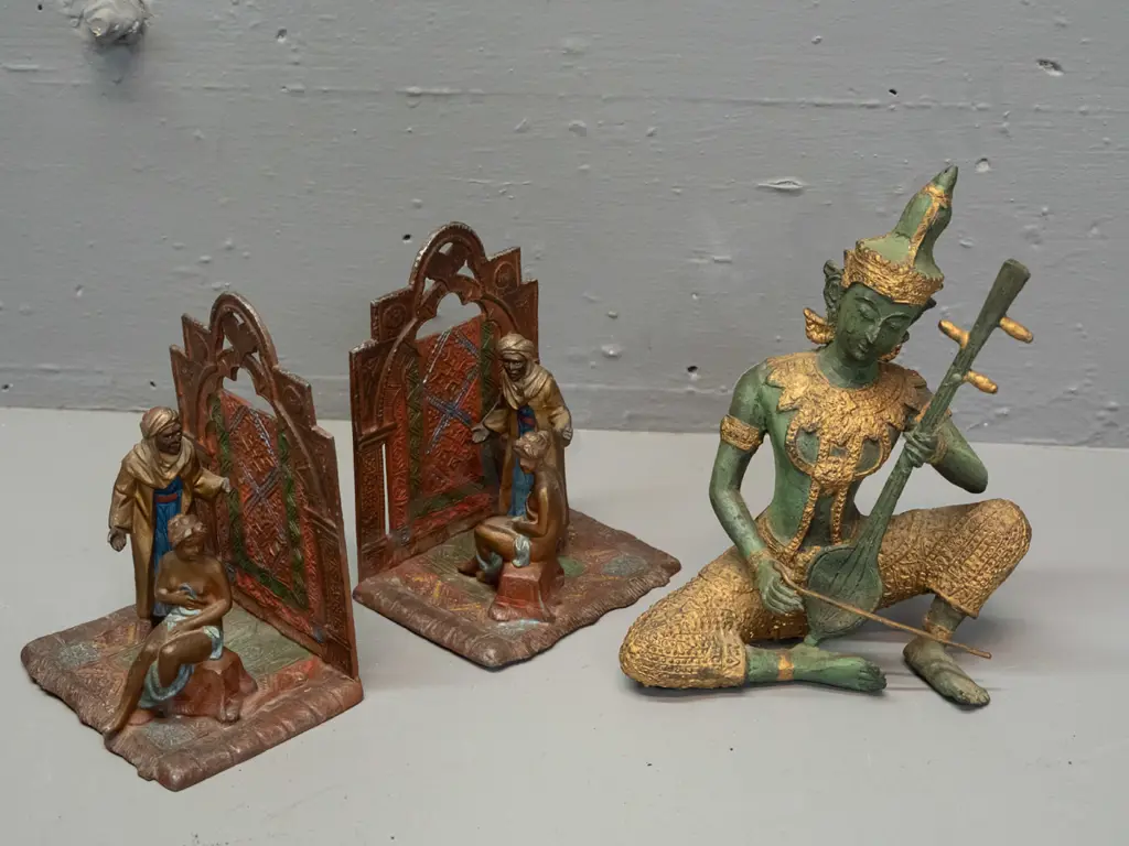 pair of Austrian cast metal book-ends with Arabian scenes and a Thai or Indonesian cast metal seated musician figure - Image 1++