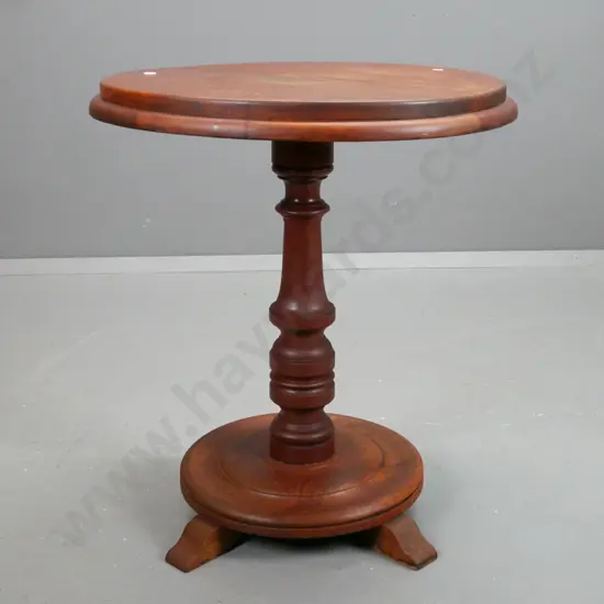 oak and mahogany circular side table with turned column support on base with sweeping legs.
