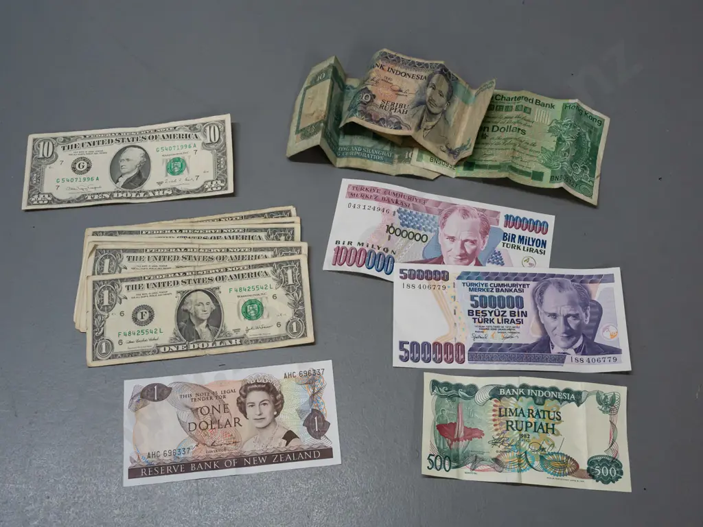 assorted bank notes - one NZ dollar, a US $10 and seven $1s, other overseas notes - some are very worn and stained Image 1++