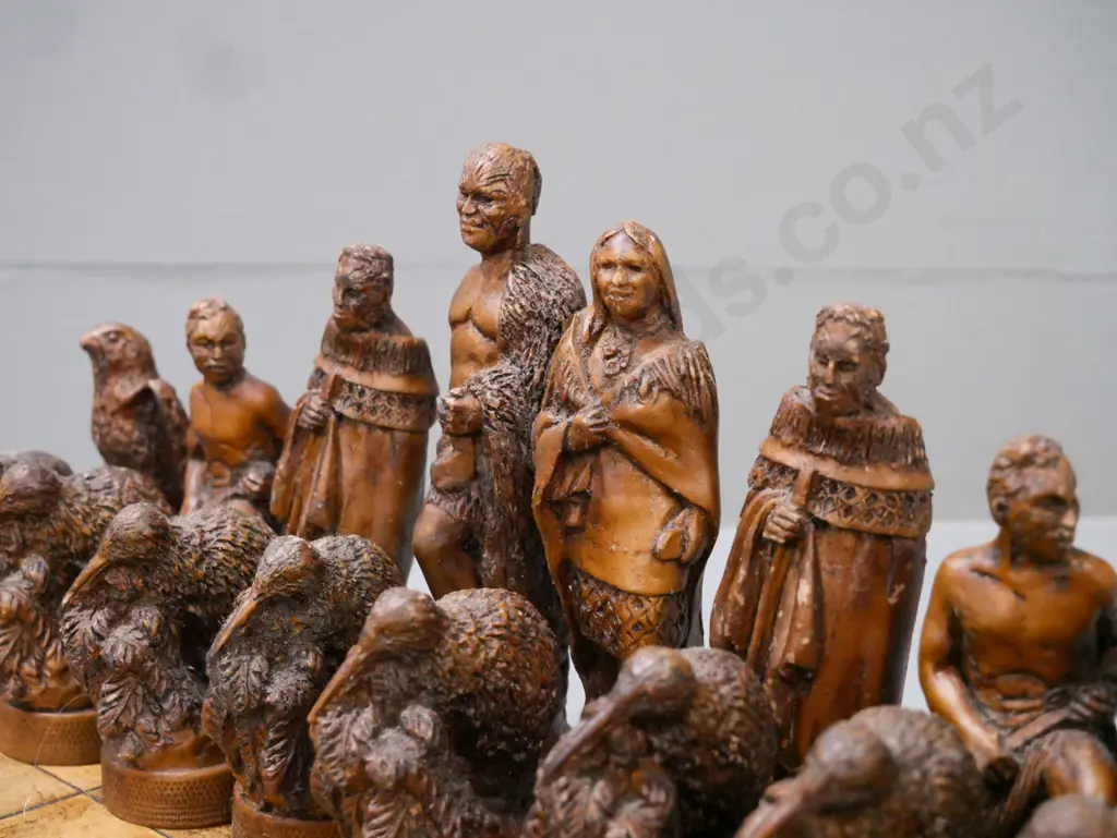Māori-themed chess set w/ composite chess pieces & leather(?) laid on chessboard. Chessboard 380x380. Tallest Image 1++