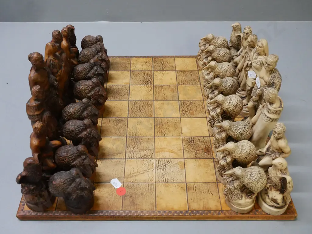 Māori-themed chess set w/ composite chess pieces & leather(?) laid on chessboard. Chessboard 380x380. Tallest Image 1++