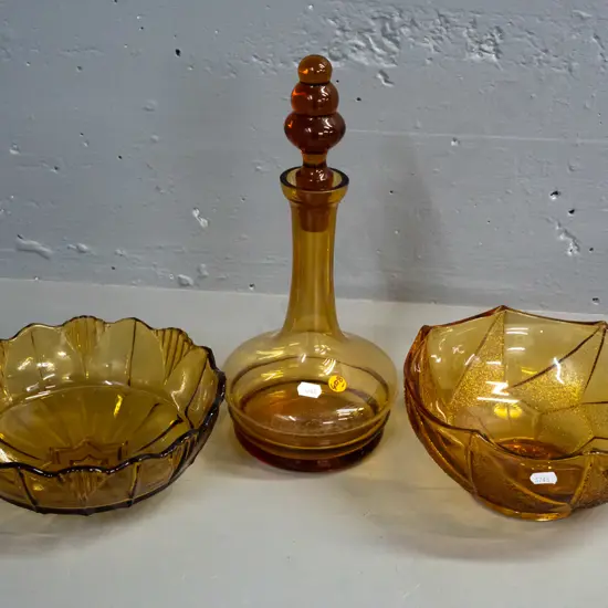 3 pieces of amber glass - stoppered decanter and 2 moulded salad bowls. Decanter has tiny nick in rim, some staining