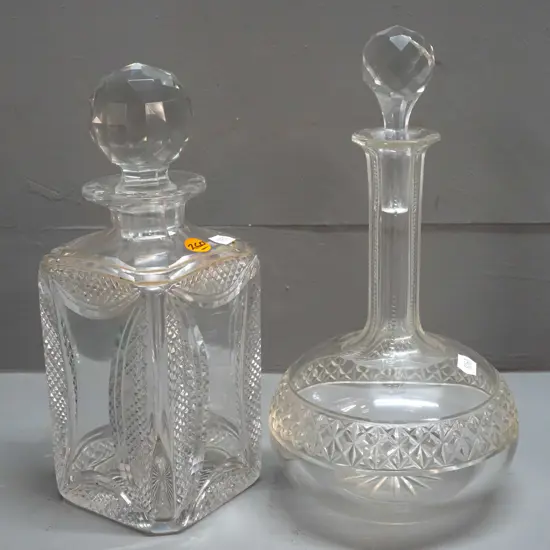 2 stoppered crystal decanters - squat round H-265 and a heavy square design with etched diamond pattern corners H-250
