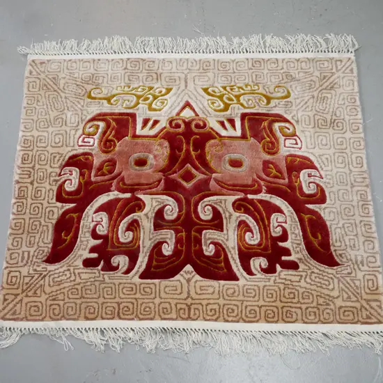 small wool floor mat with abstract Asian or Indonesian mask design 770 x 640