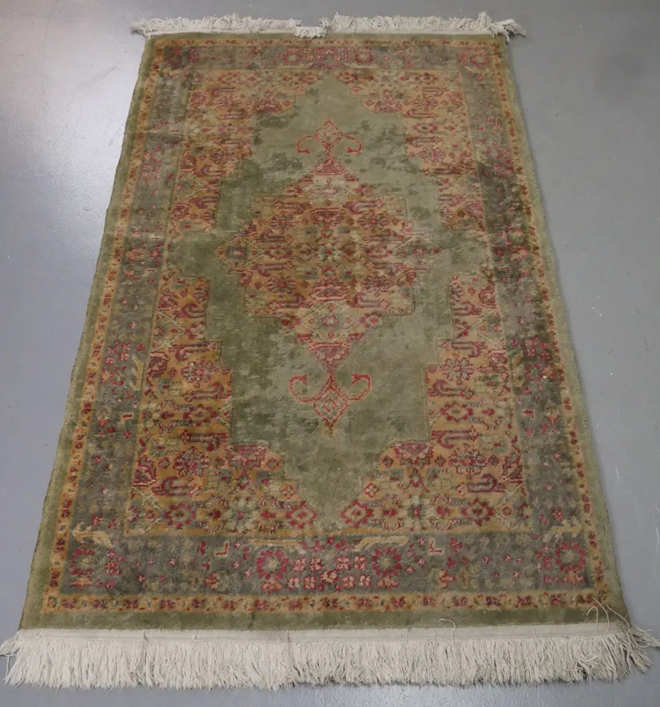 Persian-style floor rug, green ground w/ red & camel geometric & floral borders. Some fading, stains & discolouration. Image 1++