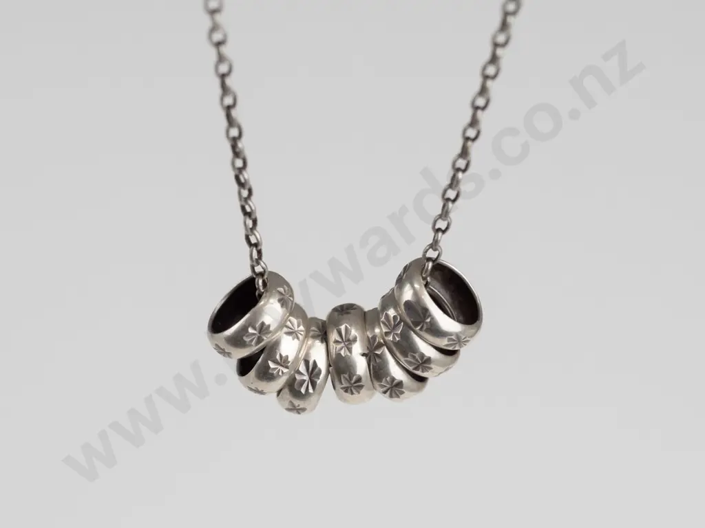 sterling silver necklace with 7 small rings stamped 925 Image 1++