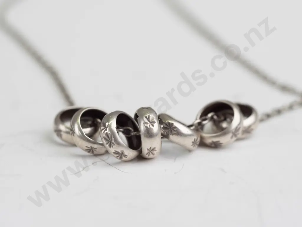 sterling silver necklace with 7 small rings stamped 925 Image 1++