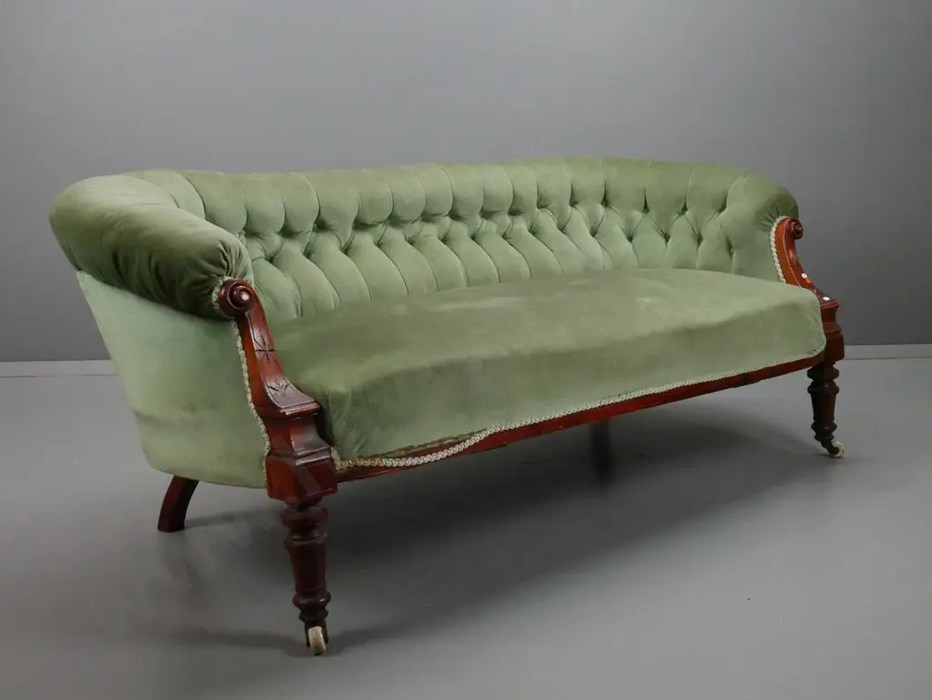 Victorian walnut settee with carved shaped arms, turned fluted legs, deep button back, porcelain & brass Image 1++
