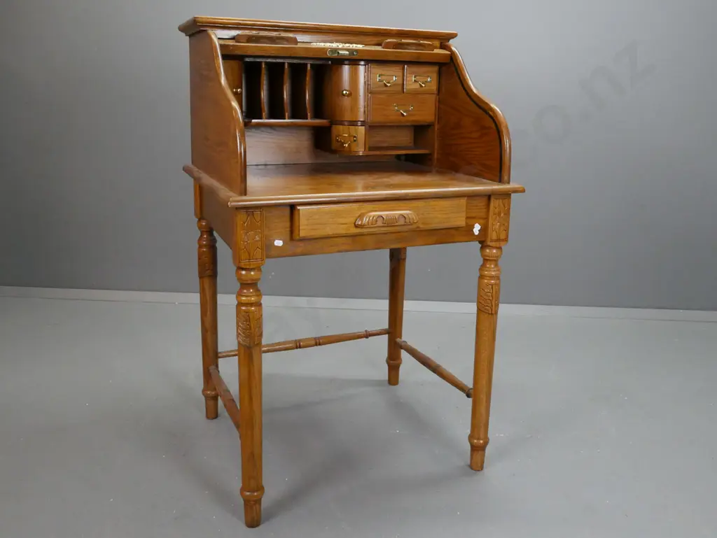 reproduction Victorian style oak wave roll top desk on turned stand with turned stretcher base. Brass label pull Image 1++