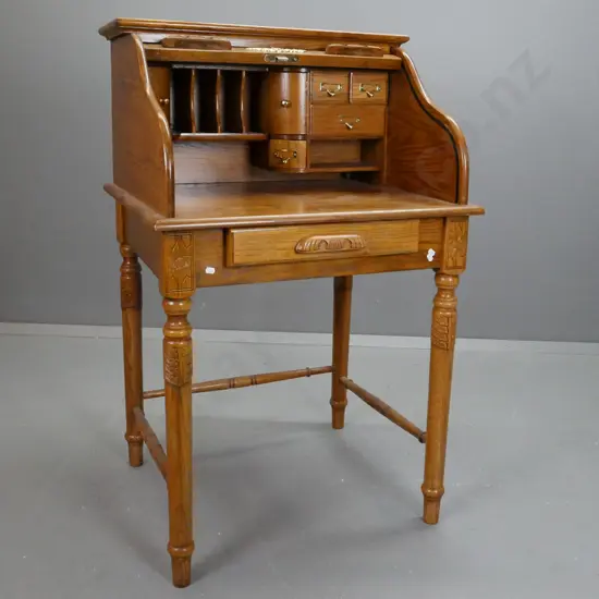 reproduction Victorian style oak wave roll top desk on turned stand with turned stretcher base. Brass label pull