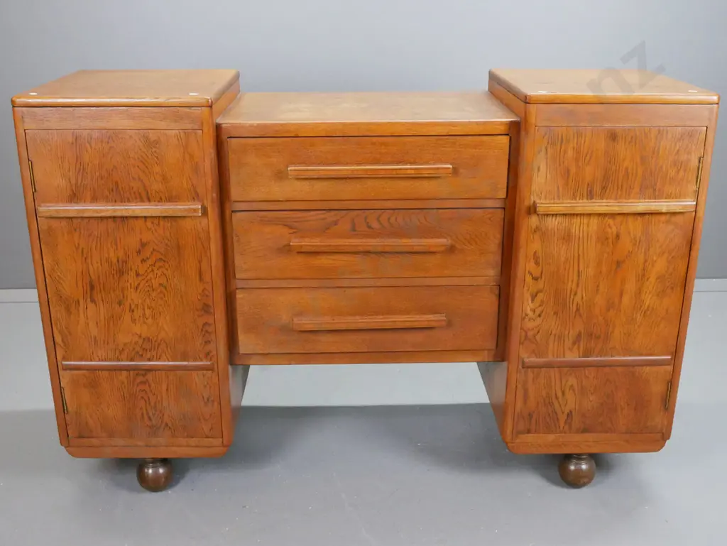 art deco oak sideboard with stepped top, 2 cupboard doors flanking 3 long drawers. Top drawer Image 1++