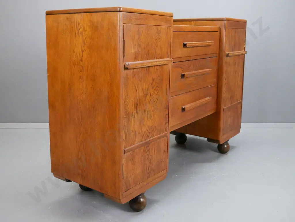 art deco oak sideboard with stepped top, 2 cupboard doors flanking 3 long drawers. Top drawer Image 1++